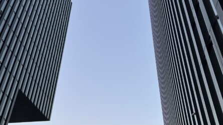 corporate-concierge-für-entscheider Zwei moderne Bürogebäude mit Blick in den Himmel – Symbol für Klarheit, Struktur und professionelle Unterstützung im Business-Alltag
