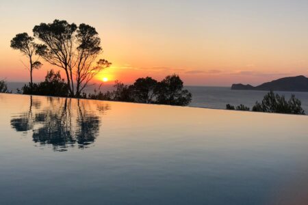 Blick vom Pool auf das offene Meer bei Sonnenuntergang