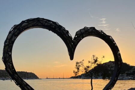 Puesta de sol en una bahía de Mallorca con una escultura de un corazón en primer plano - Propuesta en Mallorca