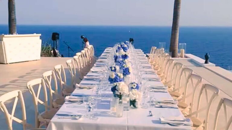 Elegante, festlich gedeckte Tafel in einer Luxusvilla auf Mallorca mit Blick auf den Pool und das offene Meer