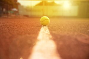 Tennisball auf Sandplatz bei Sonnenuntergang, Mallorca